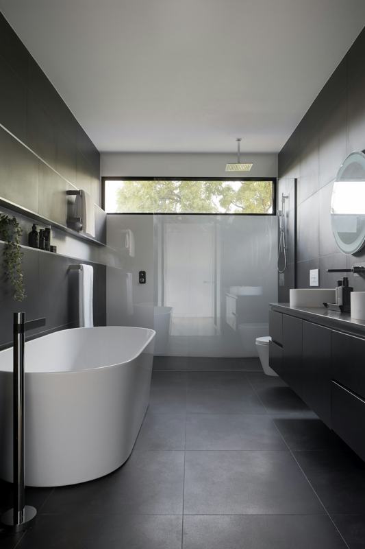 Dark stone bathroom with freestanding bathtub